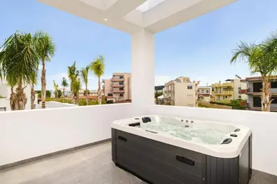 a hot tub on a balcony with palm trees at Villa Dolce Vita Evelia by Villa Plus in Ialyssos