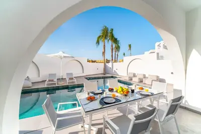 a dining room with a table and a swimming pool at Villa Dolce Vita Evelia by Villa Plus in Ialyssos