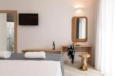 a bedroom with a bed and a mirror and a stool at Eagles Nest in Pefki Rhodes