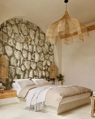 a bedroom with a stone wall and a bed at Elaia Luxury House in Archangelos