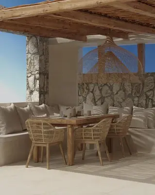 a dining room with a wooden table and chairs at Elaia Luxury House in Archangelos