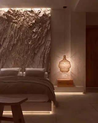 a bedroom with a bed with a stone wall at Elaia Luxury House in Archangelos