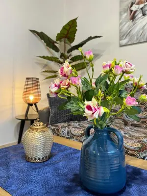 a blue vase with pink flowers on a table at Alleyhouse 83 in Kremasti