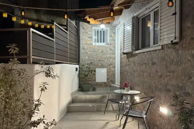 a patio with a table and chairs and a window at Alleyhouse 83 in Kremasti