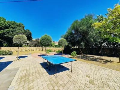 a ping pong table in a courtyard with trees at Villa Libre Mare, your cozy vacation villa in Pefki Rhodes