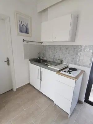 a white kitchen with a sink and a stove at 3rd floor apartment in town with sea view in Rhodes Town