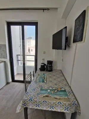 a room with a table with a television and a window at 3rd floor apartment in town with sea view in Rhodes Town