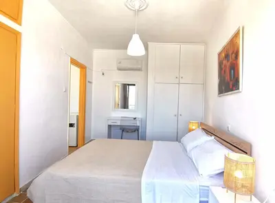 a bedroom with a white bed and a white cabinet at 3rd floor apartment in town with sea view in Rhodes Town