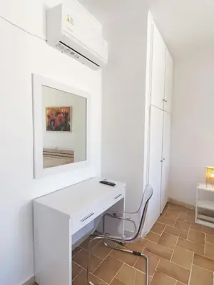 a white desk with a mirror and a chair in a room at 3rd floor apartment in town with sea view in Rhodes Town