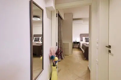 a hallway with a mirror and a room with a bed at Uni cozy city apartment in Rhodes Town