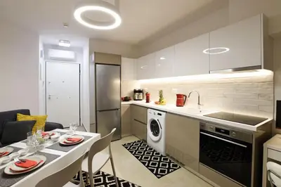 a kitchen with a table and a sink and a dishwasher at Uni cozy city apartment in Rhodes Town
