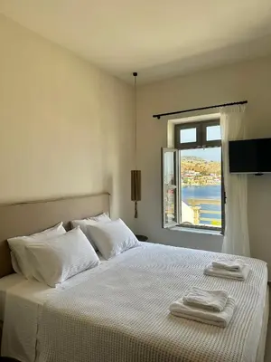 a white bedroom with a bed with towels on it at Serenity Suites in Halki