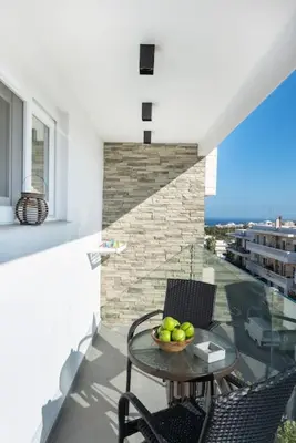 a table and chairs on a balcony with a bowl of apples at Smart Luxury Apartments #1 in Rhodes Town