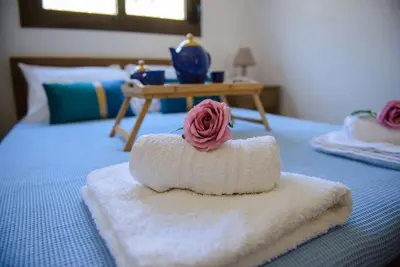 a towel with a rose on top of a bed at Blue Bay Villas , First Floor in Archangelos
