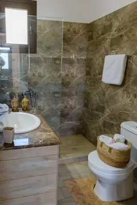 a bathroom with a toilet and a sink at Blue Bay Villas , First Floor in Archangelos