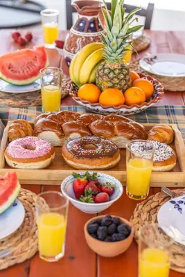 a table topped with lots of different types of pastries and fruit at Blue Bay Villas , First Floor in Archangelos