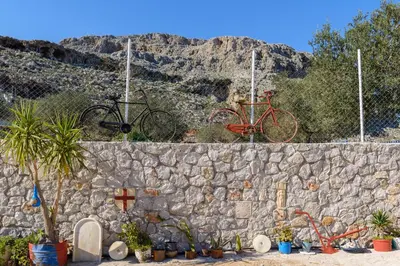 a bike is on top of a stone wall at Blue Bay Villas , First Floor in Archangelos