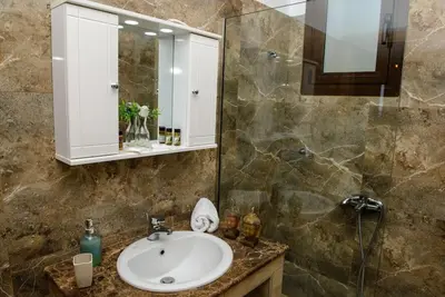 a bathroom with a sink and a mirror at Blue Bay Villas , First Floor in Archangelos