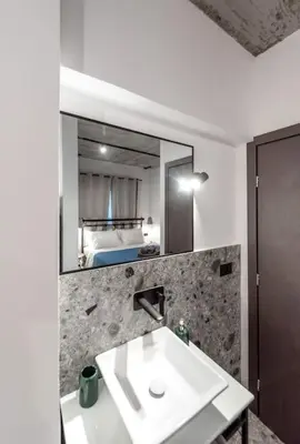 a bathroom with a sink and a mirror and a bed at Smart Luxury Apartments #2 in Rhodes Town