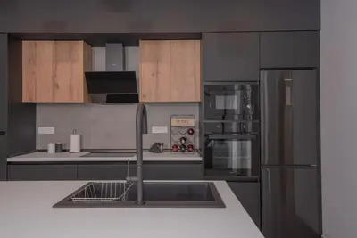 a kitchen with a sink and a refrigerator at Anthemis modern & spacious in Koskinou