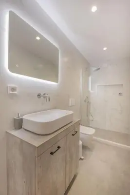 a white bathroom with a sink and a toilet at Anthemis modern & spacious in Koskinou