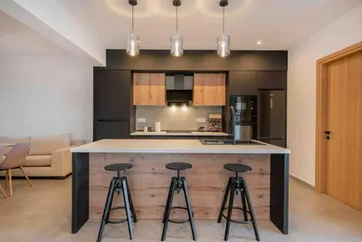 a kitchen with a counter and stools in a room at Anthemis modern & spacious in Koskinou