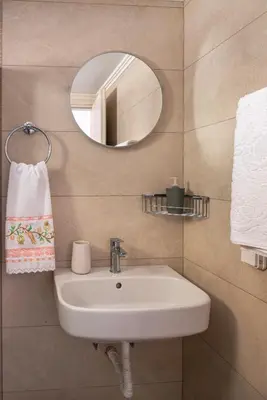 a bathroom with a sink and a mirror at Oceanis apartment in Symi