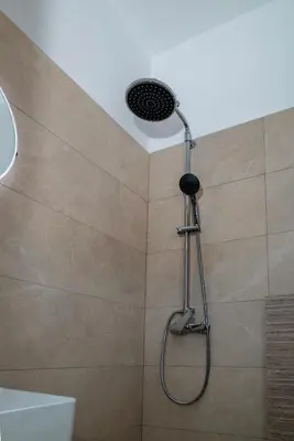 a shower with a shower head in a bathroom at Oceanis apartment in Symi