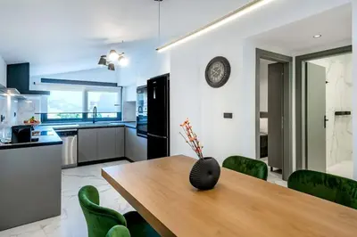 a kitchen with a wooden table and green chairs at Rhodes Center Luxury Apartments #1 in Rhodes Town