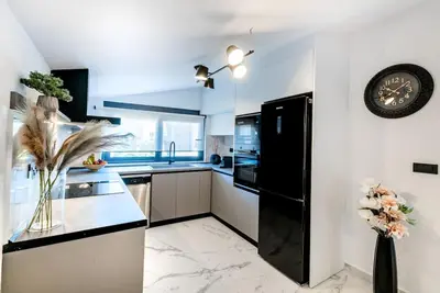 a kitchen with a black refrigerator and a clock on the wall at Rhodes Center Luxury Apartments #1 in Rhodes Town