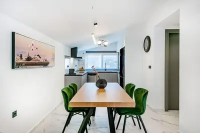 a dining room with a table and green chairs at Rhodes Center Luxury Apartments #1 in Rhodes Town