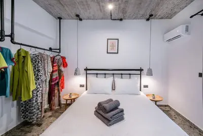a bedroom with a bed and a rack of clothes at Smart Luxury Apartments #3 in Rhodes Town