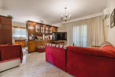 a living room with a red couch and a television at Casa Garden in Archangelos