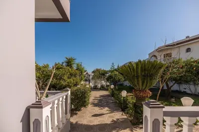 a walkway leading to a house with a white fence at Casa Garden in Archangelos