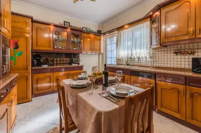 a kitchen with wooden cabinets and a table with wine glasses at Casa Garden in Archangelos