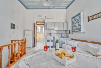 a kitchen with a table with a bottle of wine at Afaia Apartments in Symi