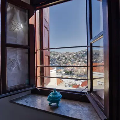 a blue fire hydrant sitting in front of a window at Afaia Apartments in Symi