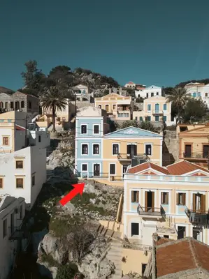 a red arrow in a city with buildings at Afaia Apartments in Symi