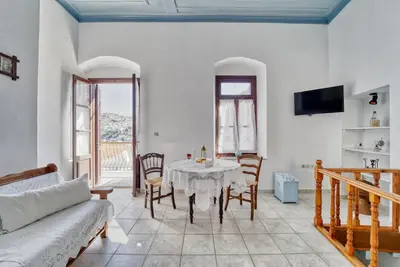 a living room with a table and chairs and a couch at Afaia Apartments in Symi