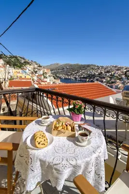 a table with cookies and coffee on a balcony at Afaia Apartments in Symi