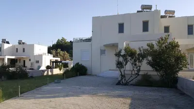 a white house with a driveway in front of it at Marilia relaxing home, Afantou in Afantou