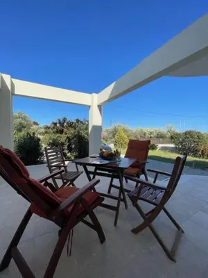 a patio with a table and chairs on a porch at Marilia relaxing home, Afantou in Afantou