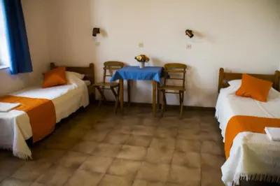 a room with two beds and a table and chairs at Medieval Rose Guest House in Rhodes Town