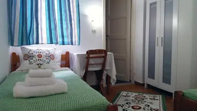 a bedroom with a bed with a pillow and a chair at Medieval Rose Guest House in Rhodes Town
