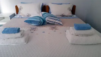 a bed with towels and pillows on it at Medieval Rose Guest House in Rhodes Town