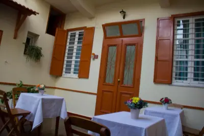 two tables with white table cloths and a red door at Medieval Rose Guest House in Rhodes Town