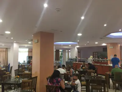 a group of people sitting at tables in a restaurant at Romantza Mare in Kallithea Rhodes