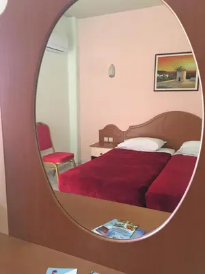 a bedroom with a red bed and a mirror at Romantza Mare in Kallithea Rhodes
