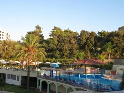 a resort with a pool and tables and trees at Romantza Mare in Kallithea Rhodes