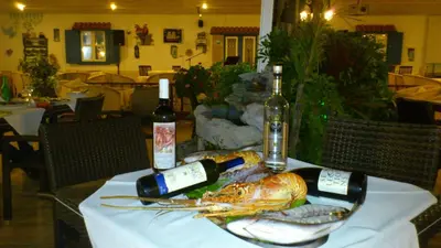a table with a lobster and two bottles of wine at Romantza Mare in Kallithea Rhodes